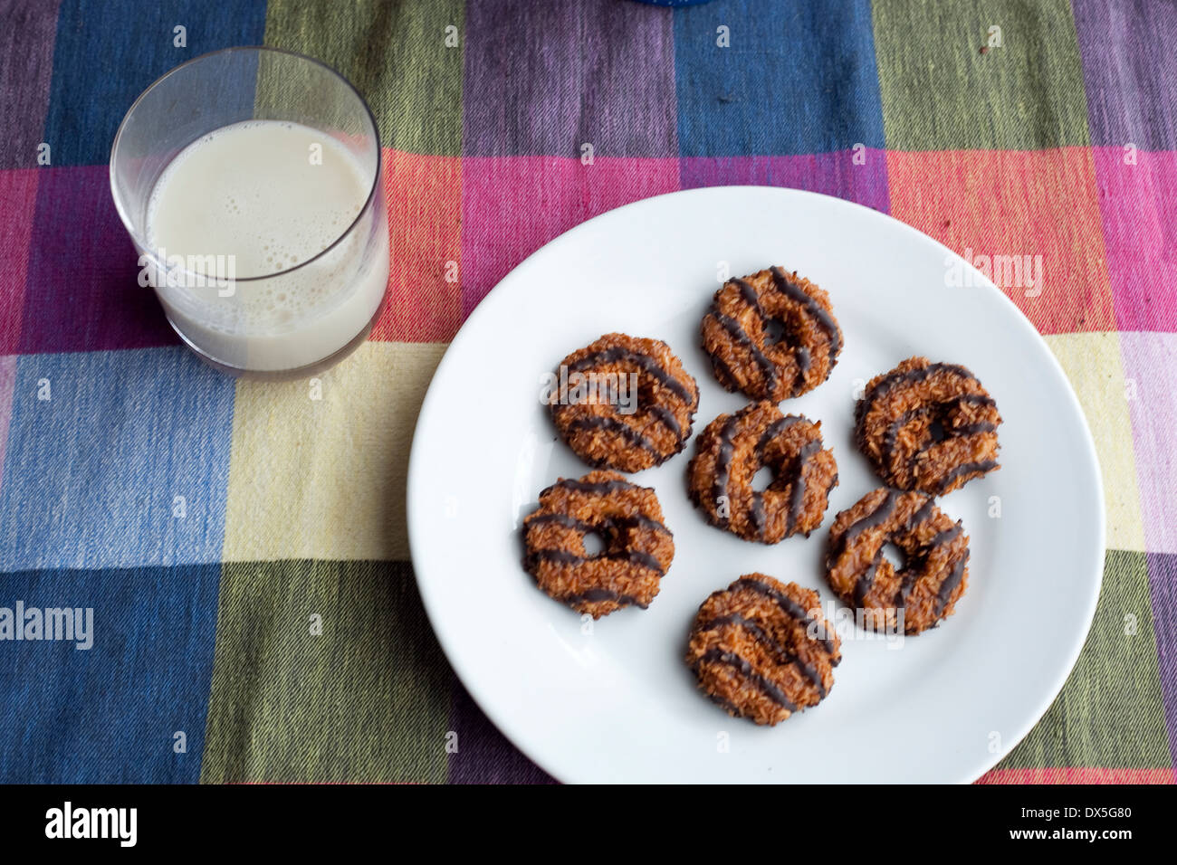 A plate of Girl Scout Cookies. Samoas/ Caramel deLites with a glass of