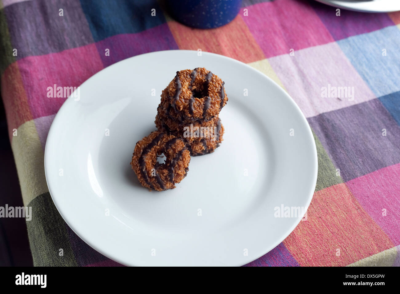 A plate of Girl Scout Cookies. Samoas/ Caramel deLites with a glass of
