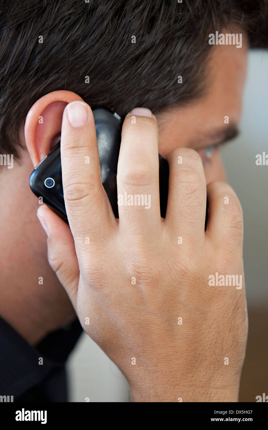 Man holding cell phone to ear and talking, close up Stock Photo