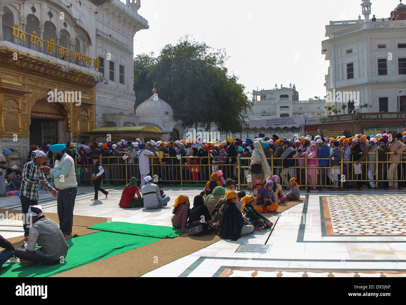 Queue of devotees with some sitting in the Golden Temple in Amritsar, being a holiday, huge rush of devotees to visit Sikh site Stock Photo
