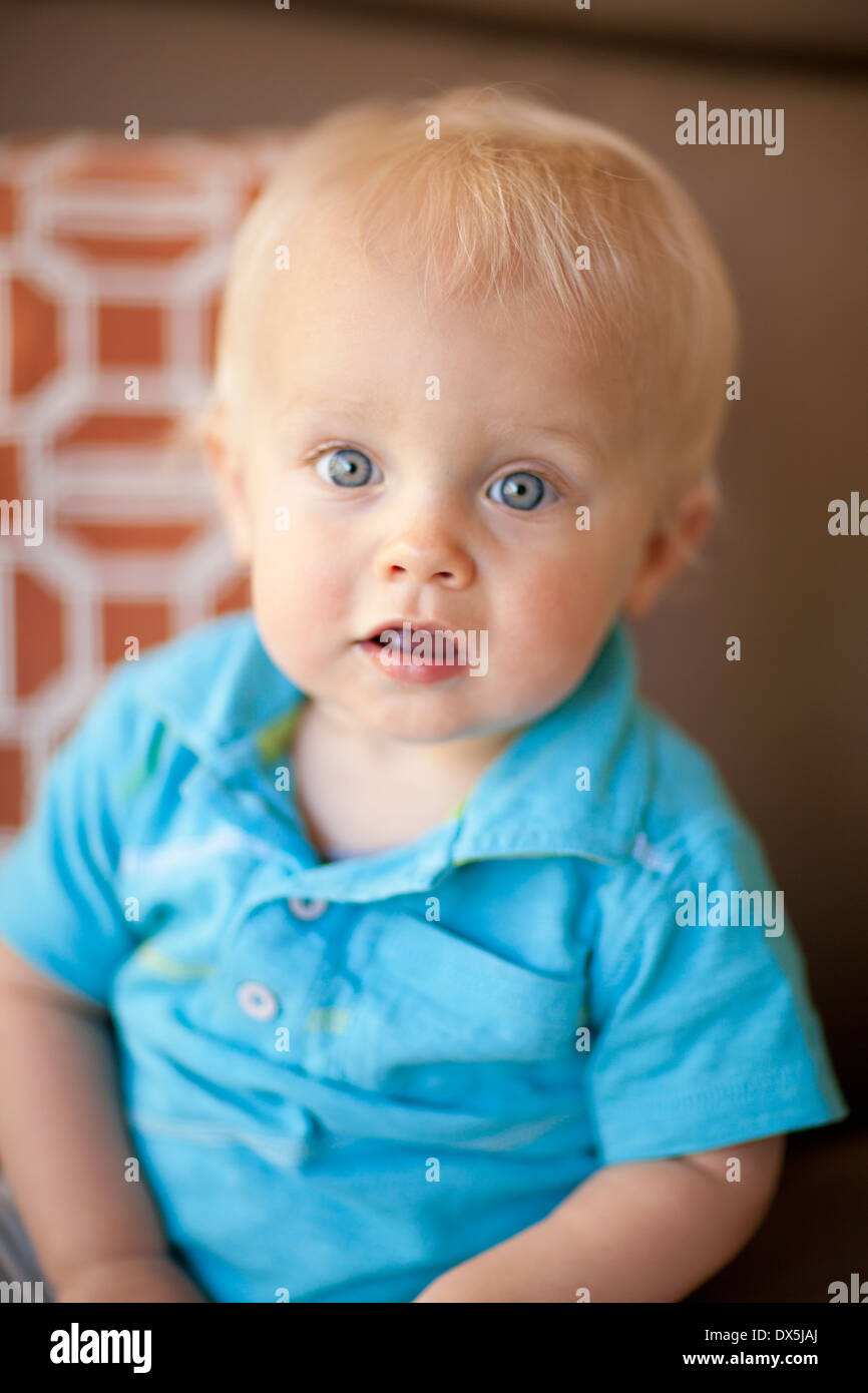 Wide-eyed baby boy with blonde hair and blue eyes, portrait, close up Stock Photo