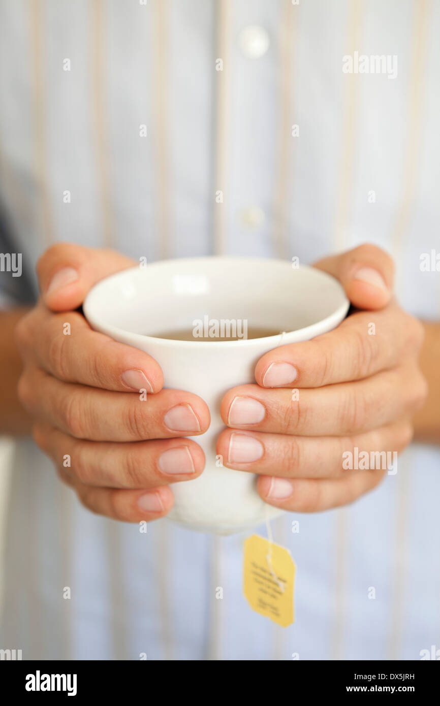 Man holding teacup with warm tea, close up Stock Photo