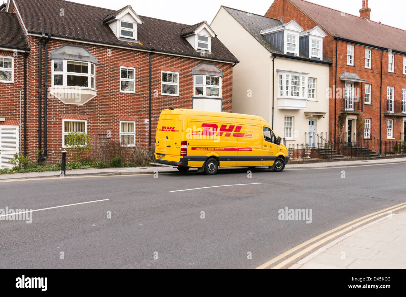 Yellow DHL parcel courier delivery van parked in UK street in front of