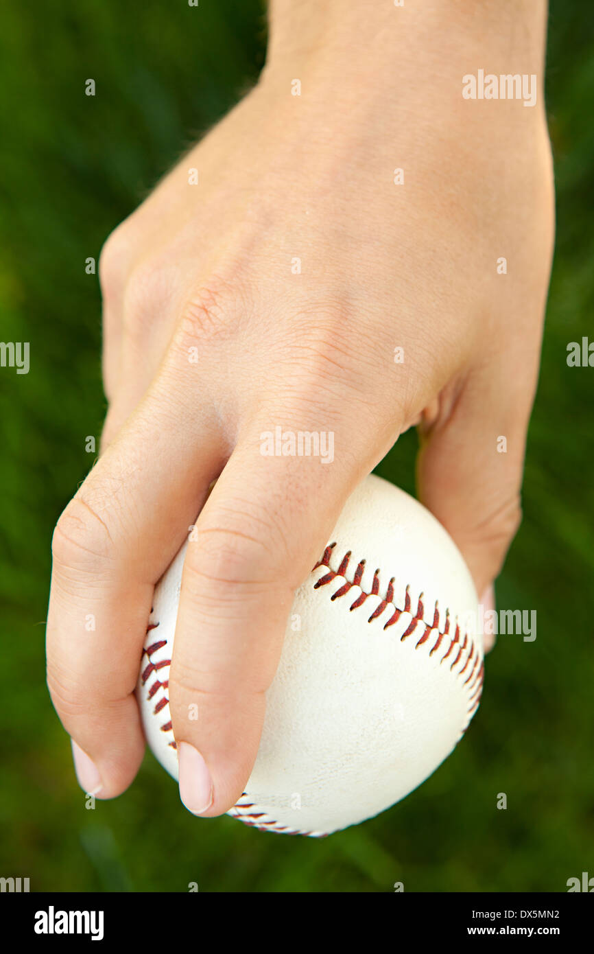 Man's hand holding baseball in pitching stance, close up, high angle view Stock Photo