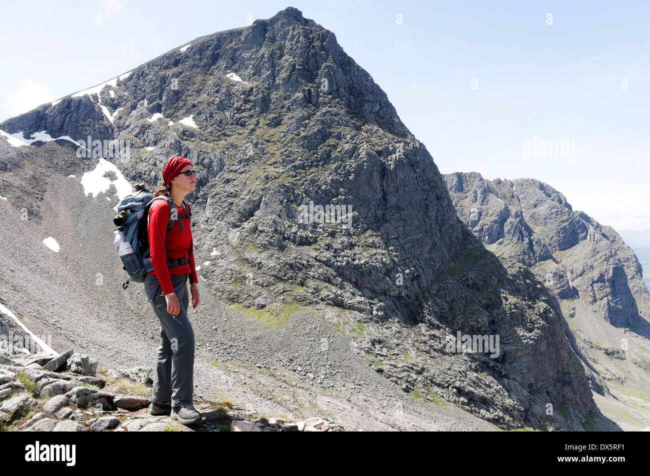 A hillwalker on the Carn Mor Dearg (CMD) arete route of Ben Nevis in the Scottish Highlands with the summit of Ben Nevis beyond Stock Photo