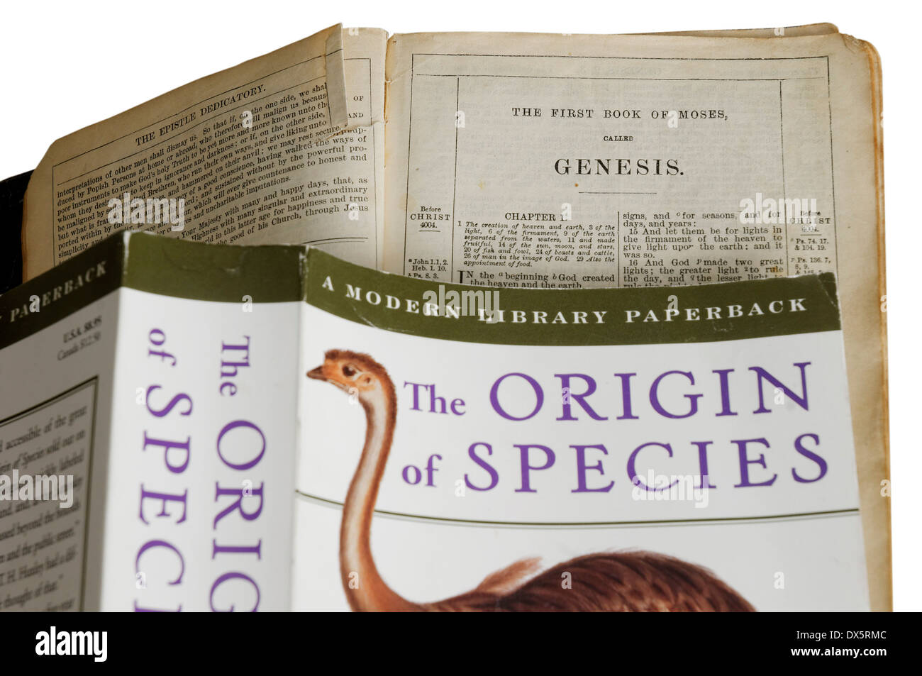 The Origin of Species by Charles Darwin and the bible open at the  book of genesis Stock Photo