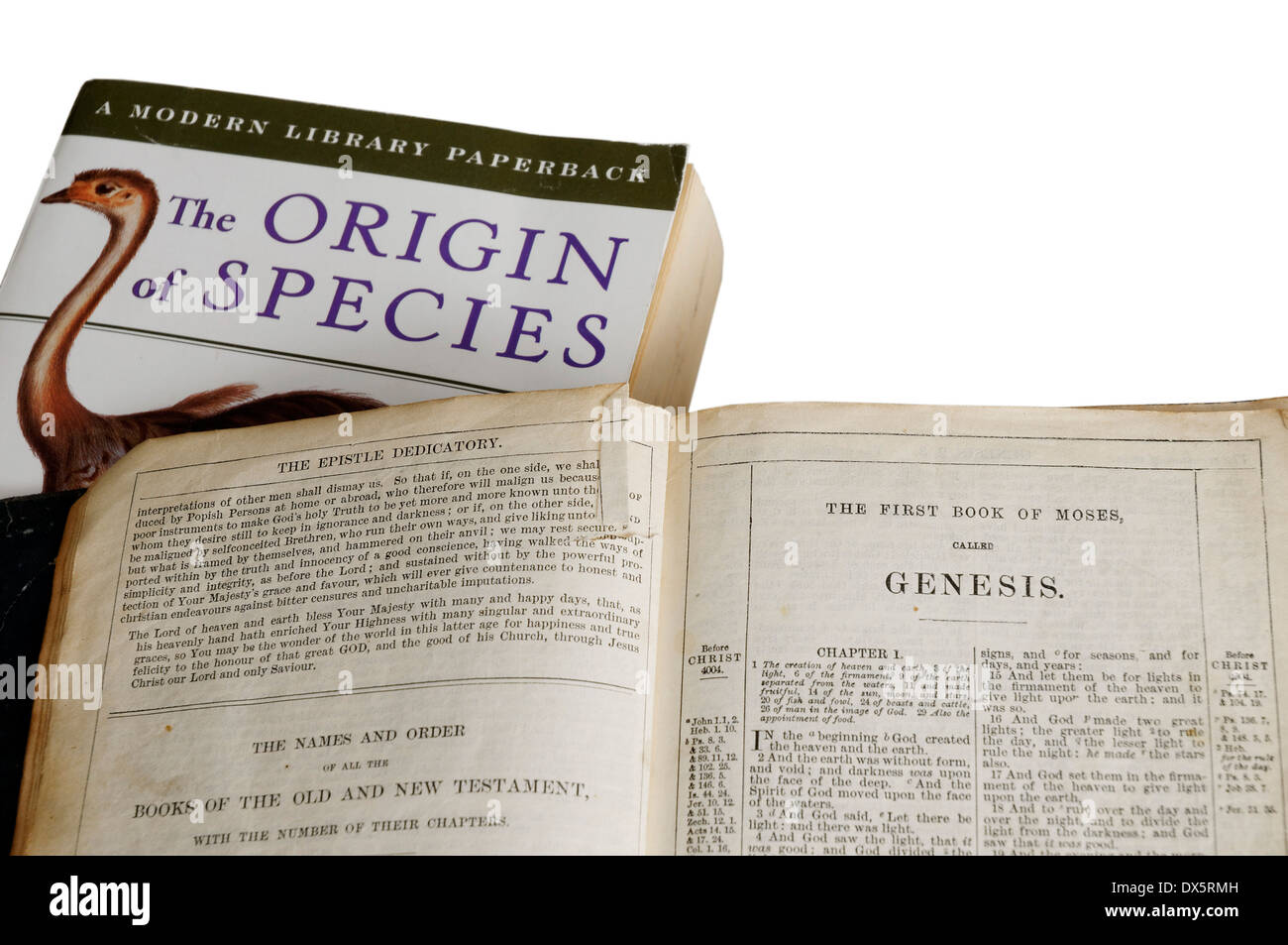 The Origin of Species by Charles Darwin and the bible open at the  book of genesis Stock Photo