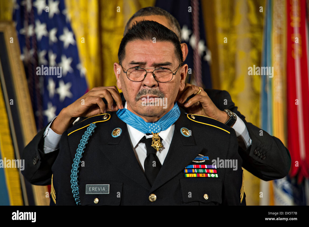 US President Barack Obama awards the Medal of Honor to Sgt. Santiago J. Erevia during a ceremony at the White House March 18, 2014 in Washington D.C. Erevia earned the Medal of Honor for his courageous actions while serving as radio telephone operator during a search and clear mission near Tam Ky, Republic of Vietnam May 21, 1969. Stock Photo