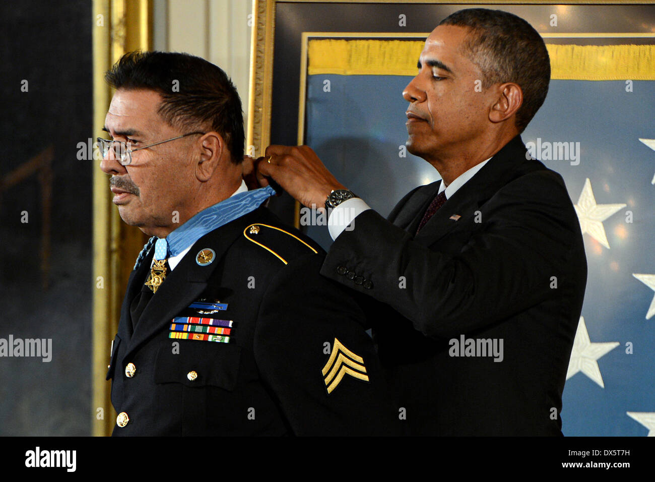 US President Barack Obama awards the Medal of Honor to Sgt. Santiago J. Erevia during a ceremony at the White House March 18, 2014 in Washington D.C. Erevia earned the Medal of Honor for his courageous actions while serving as radio telephone operator during a search and clear mission near Tam Ky, Republic of Vietnam May 21, 1969. Stock Photo