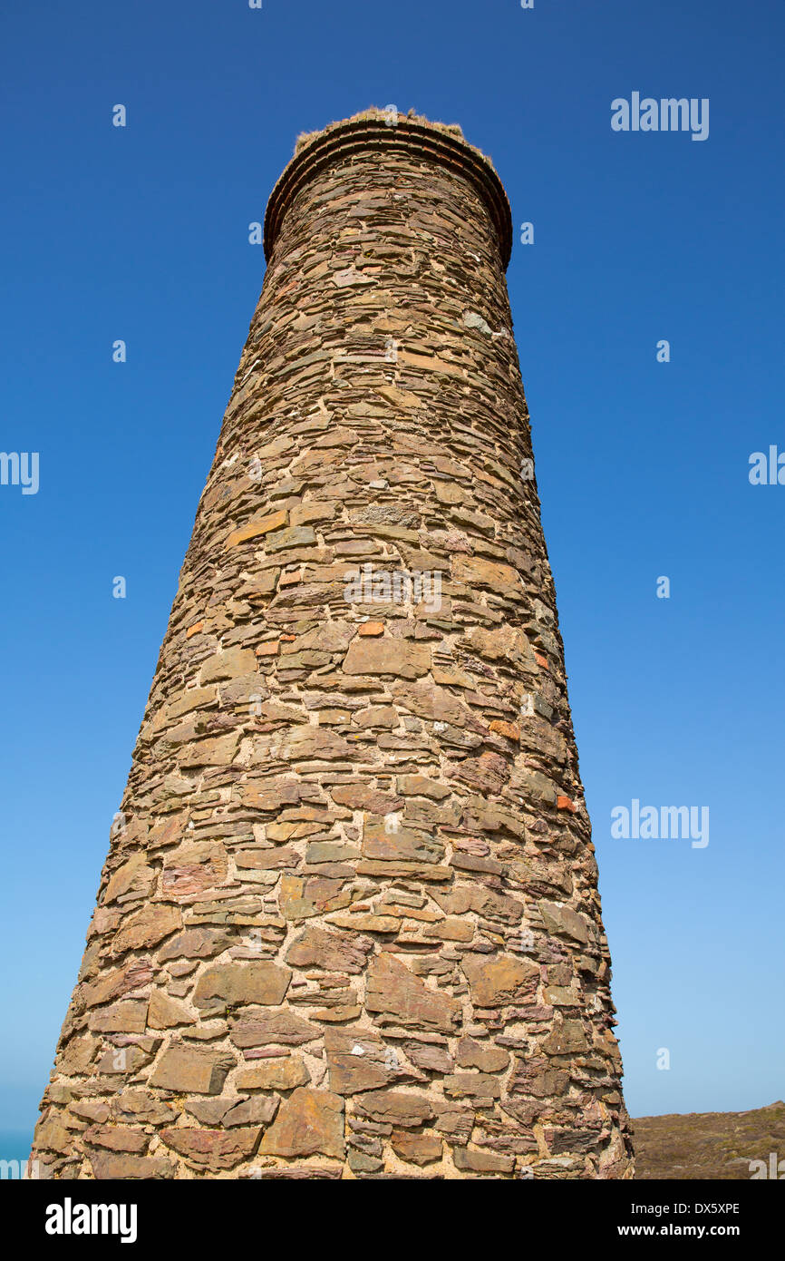 Tall industrial chimney against blue sky from tin mine Stock Photo