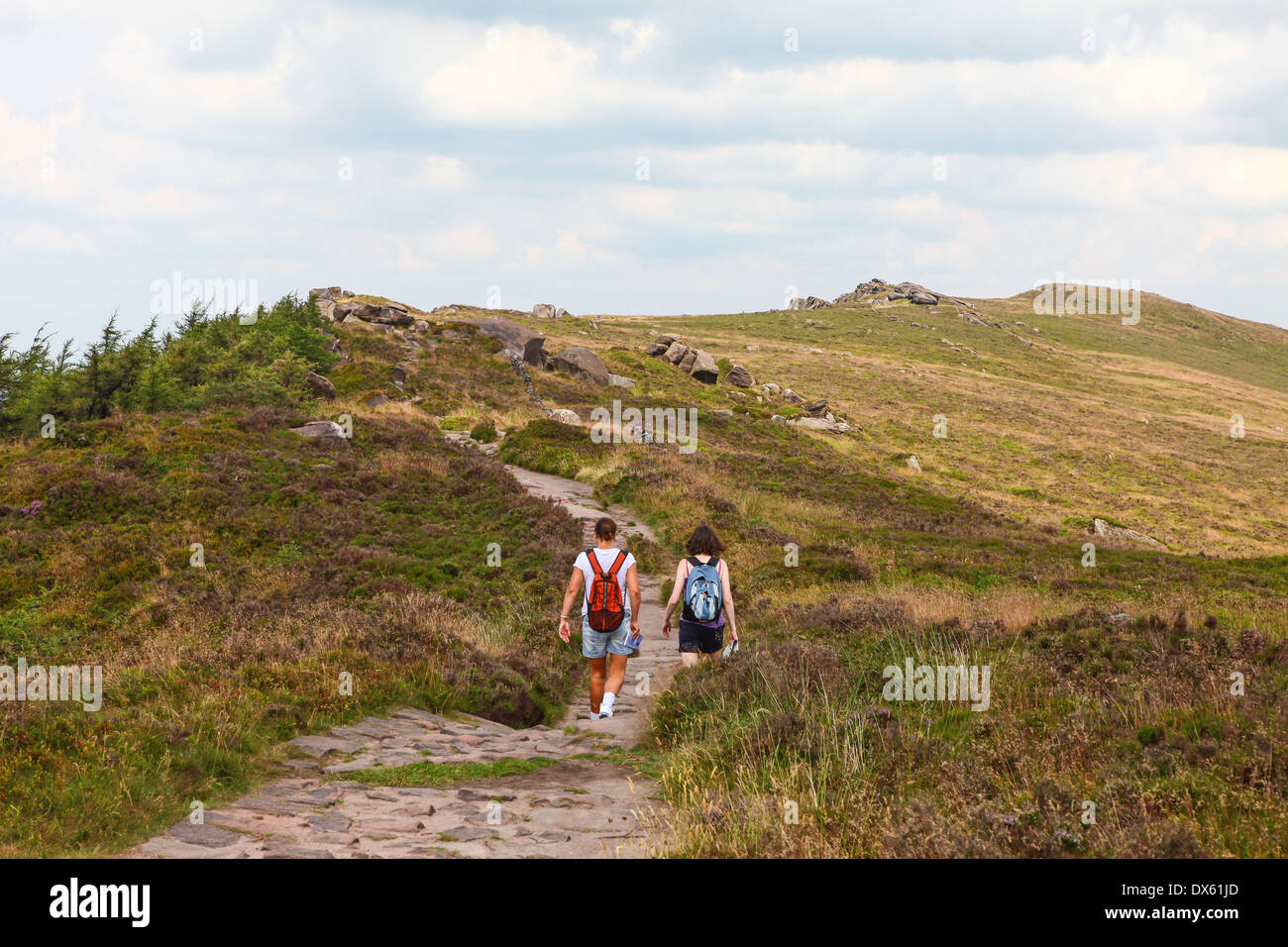 2 people walking along the paved path on top of The Roaches Staffordshire Stock Photo