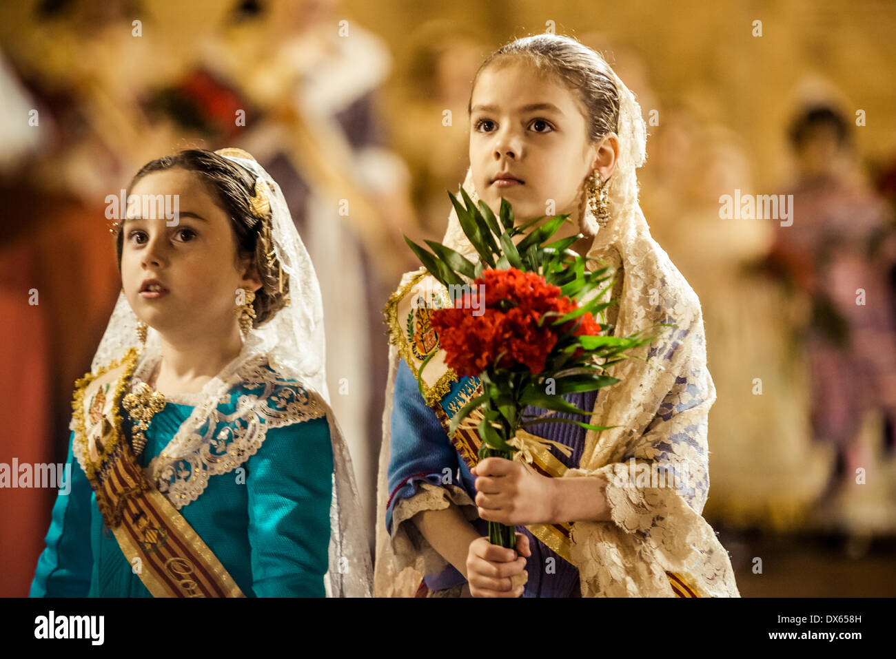 Valencia, Spain. March 18th, 2014: A little Fallera finally offers her flower bouquet to the Virgin and hands it over to be placed at the virgins image. Credit:  matthi/Alamy Live News Stock Photo