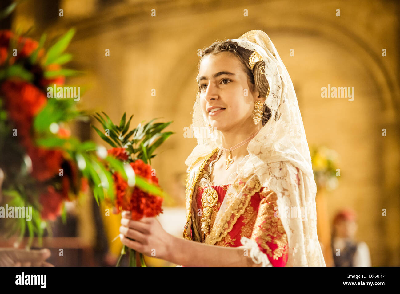 Valencia, Spain. March 18th, 2014: A young Fallera finally offers her flower bouquet to the Virgin and hands it over to be placed at the virgins image. Credit:  matthi/Alamy Live News Stock Photo