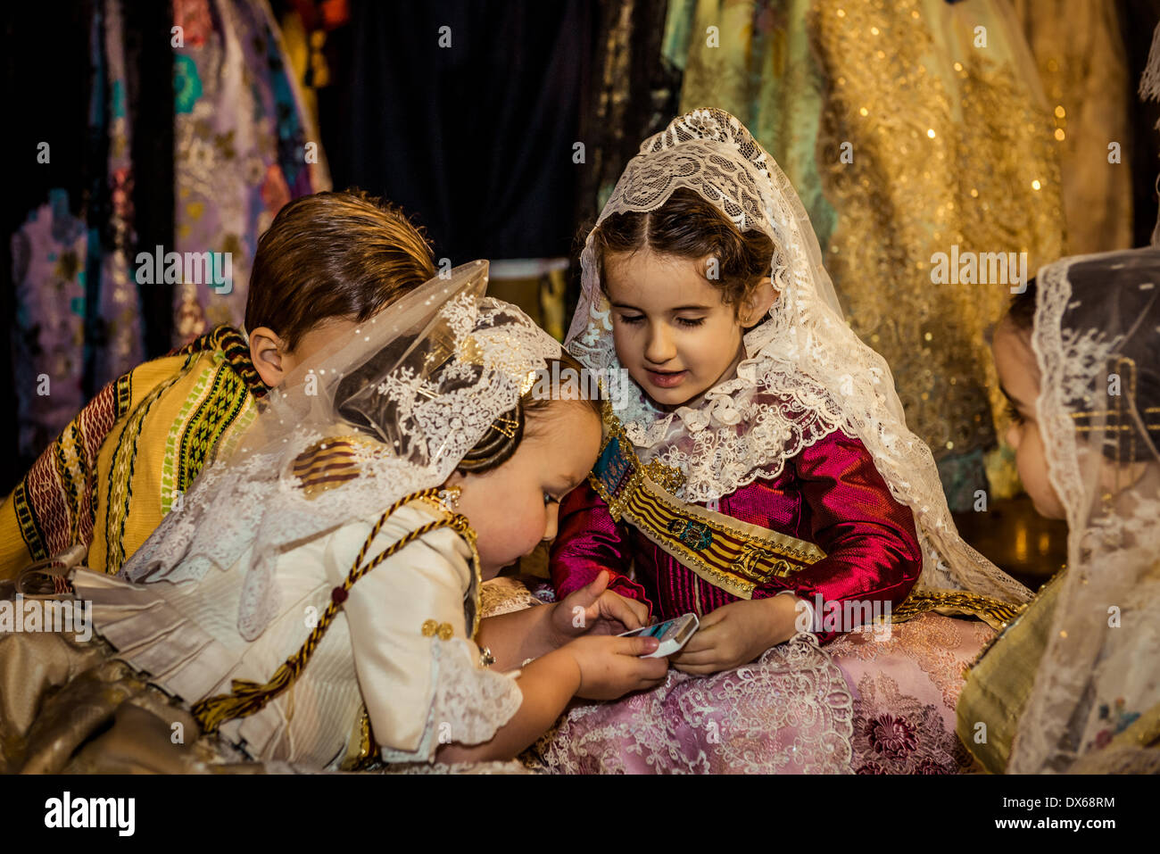 Valencia, Spain. March 18th, 2014: Little Falleras play on the floor in front of the image of the Lady of the Forsaken, Valencia's patron Saint, after a two days flower offering has ended Credit:  matthi/Alamy Live News Stock Photo