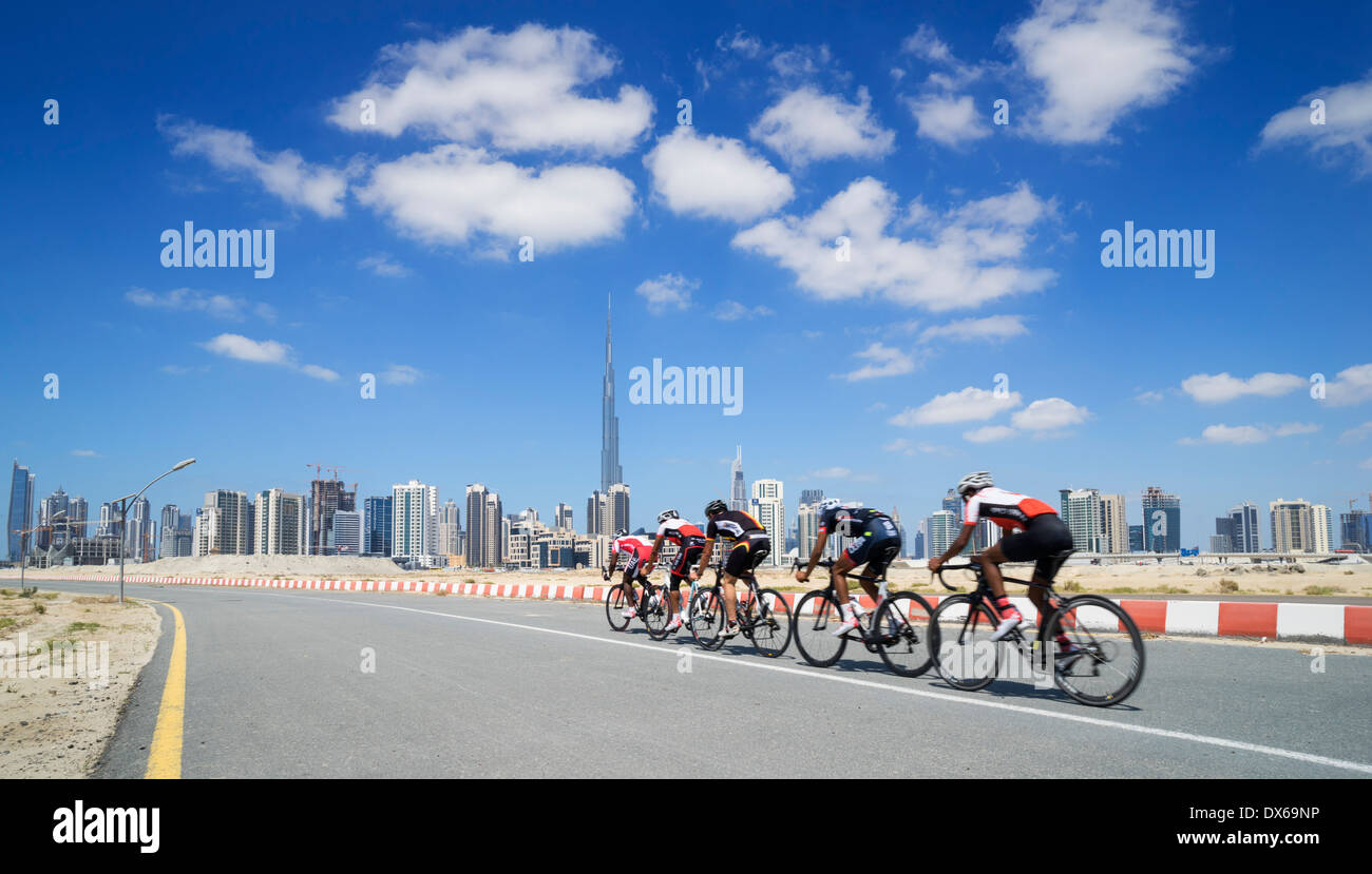 Cyclists on cycle track with skyline of Dubai in United Arab Emirates Stock Photo