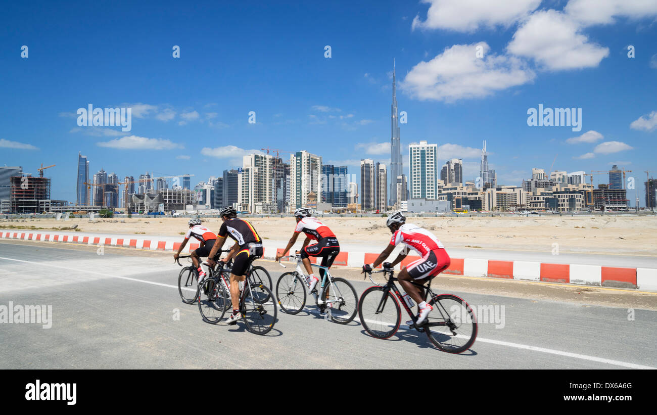 Cyclists on cycle track with skyline of Dubai in United Arab Emirates Stock Photo