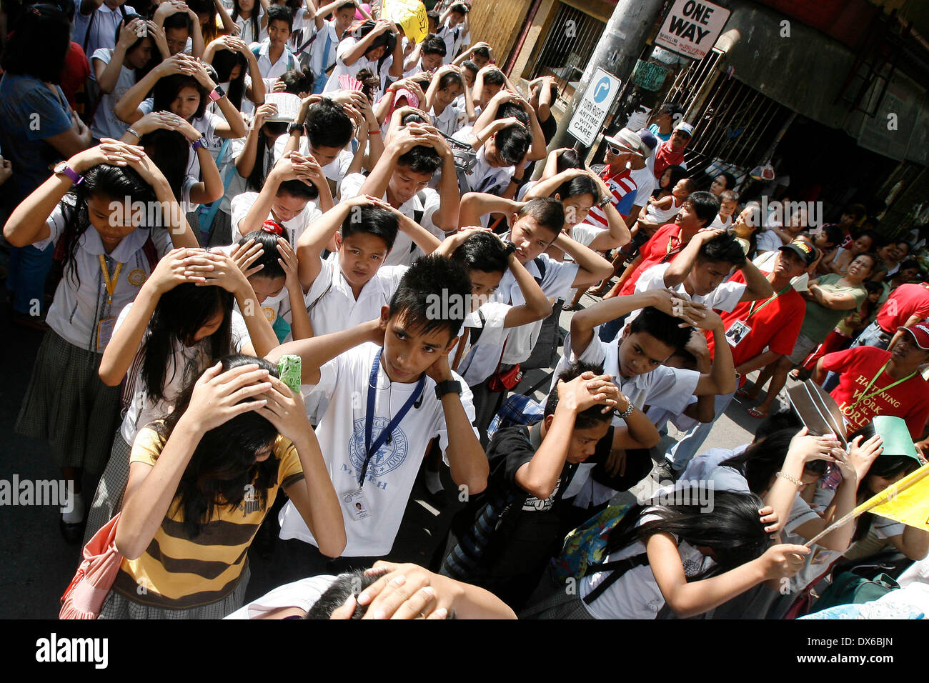 Quezon City, Philippines. 19th Mar, 2014. Students cover their heads ...