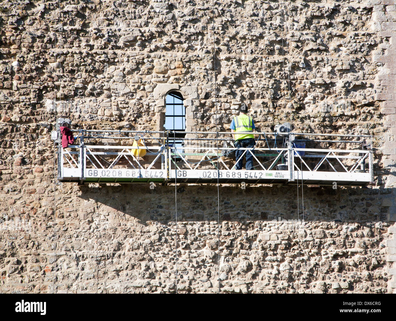 Stonemasons doing maintenance repairs to the stone walls of Framlingham castle, Suffolk, England