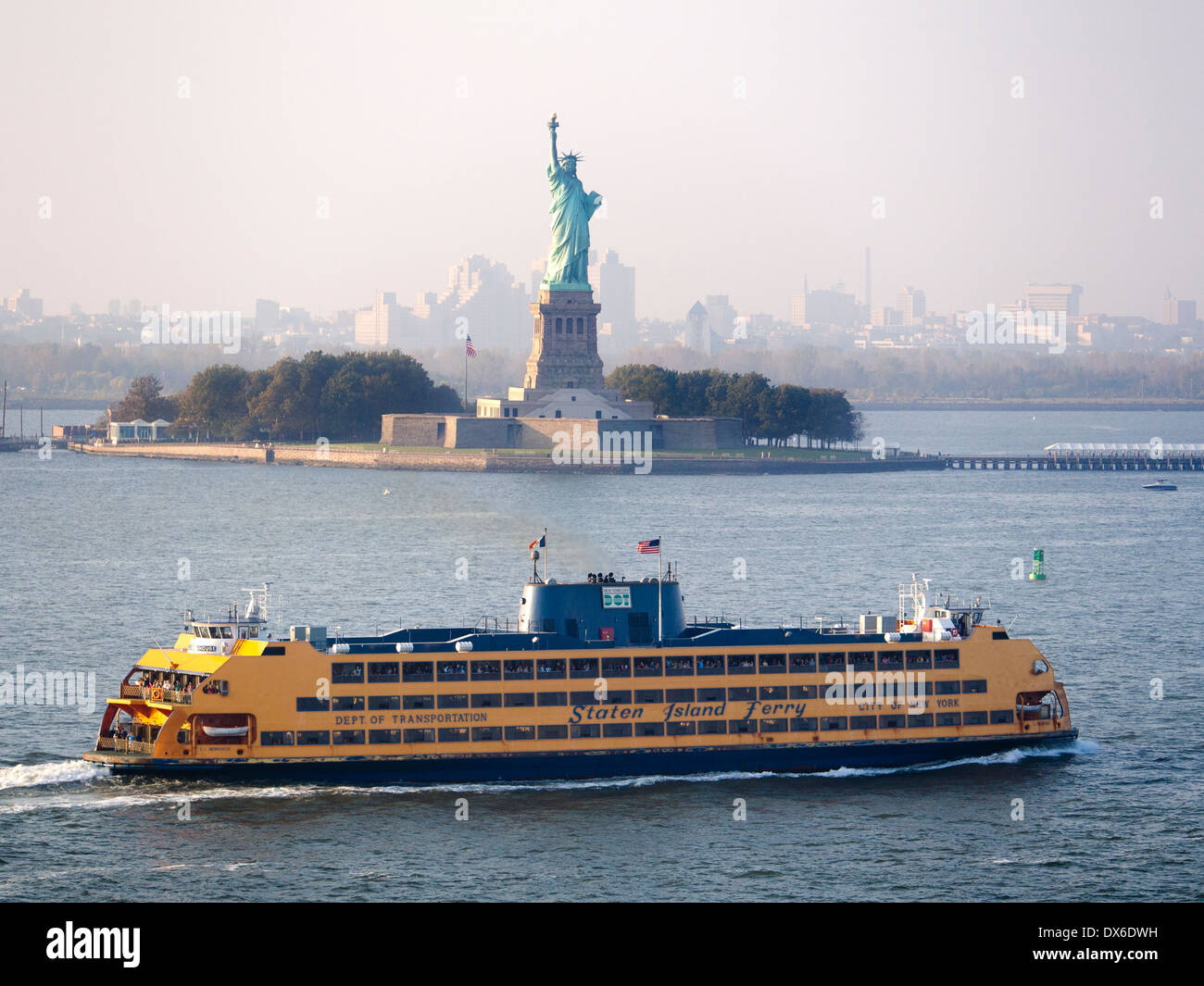 A Staten Island ferry passing the Statue of Liberty in New York Stock Photo