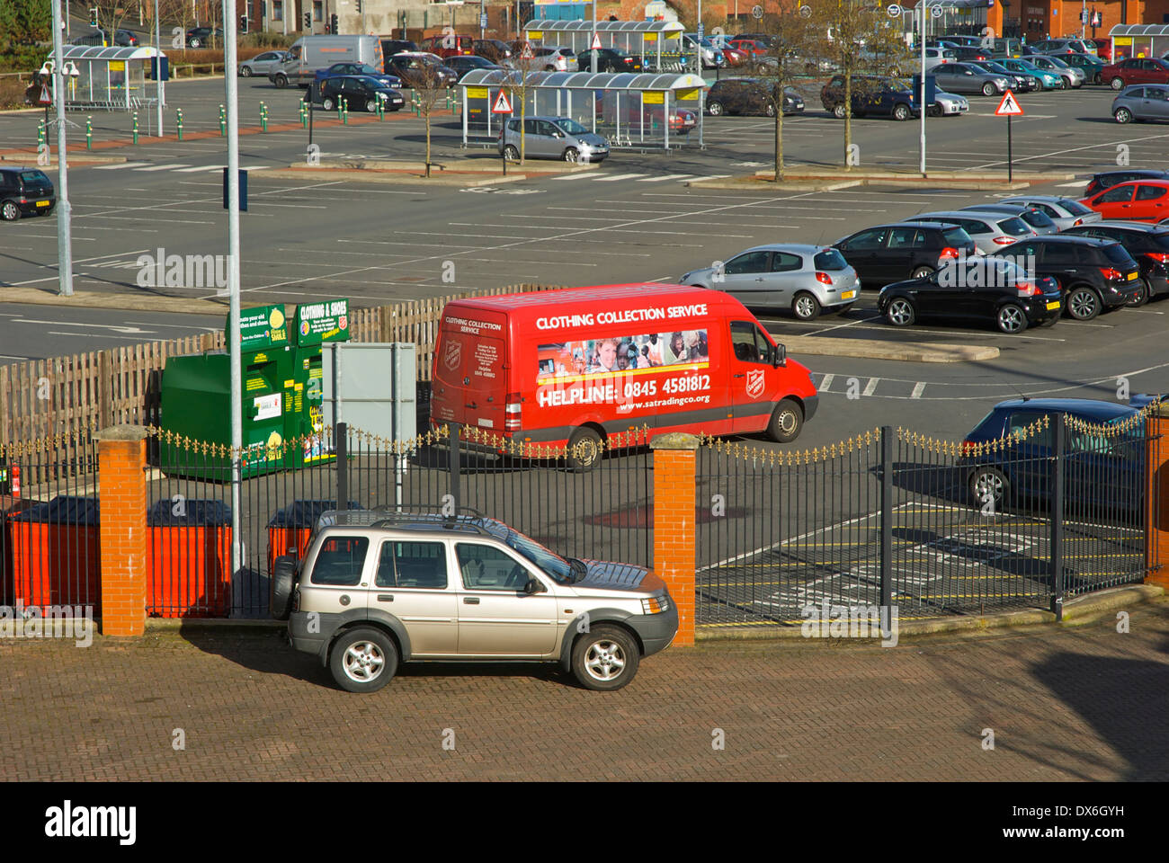 Van collecting clothes from recycling point in supermarket carpark