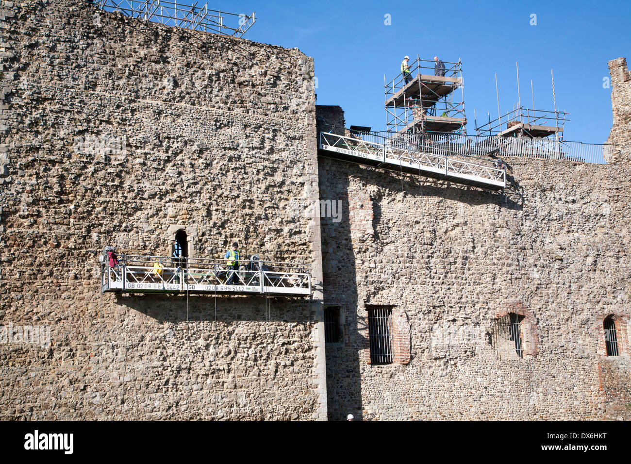 Stonemasons doing maintenance repairs to the stone walls of Framlingham castle, Suffolk, England