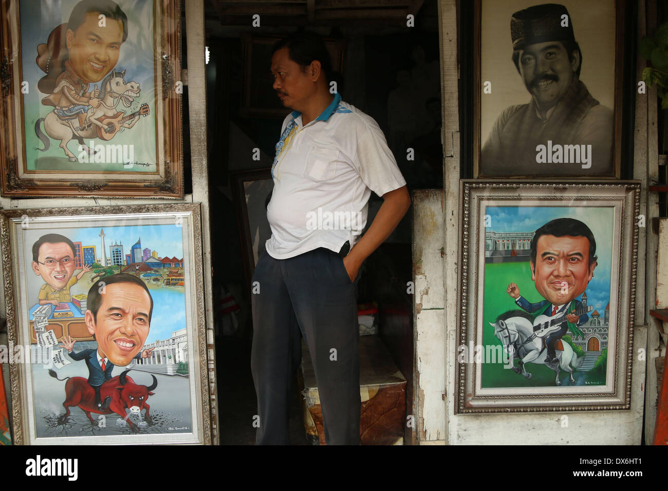 Jakarta, DKI Jakarta, Indonesia. 19th Mar, 2014. An artist painter stands near display of a painting of Jakarta Governor Joko Widodo( Left Below) and A Dangdut Musician, Rhoma Irama (Right Below) at Street Painting Shop Vendor in Jakarta. March 19, 2014 . Joko Widodo who is running for president for the Indonesian Democratic Party of Struggle (PDI-P) and Rhoma Irama a president candidate for National Awakening Party (PKB). Stock Photo