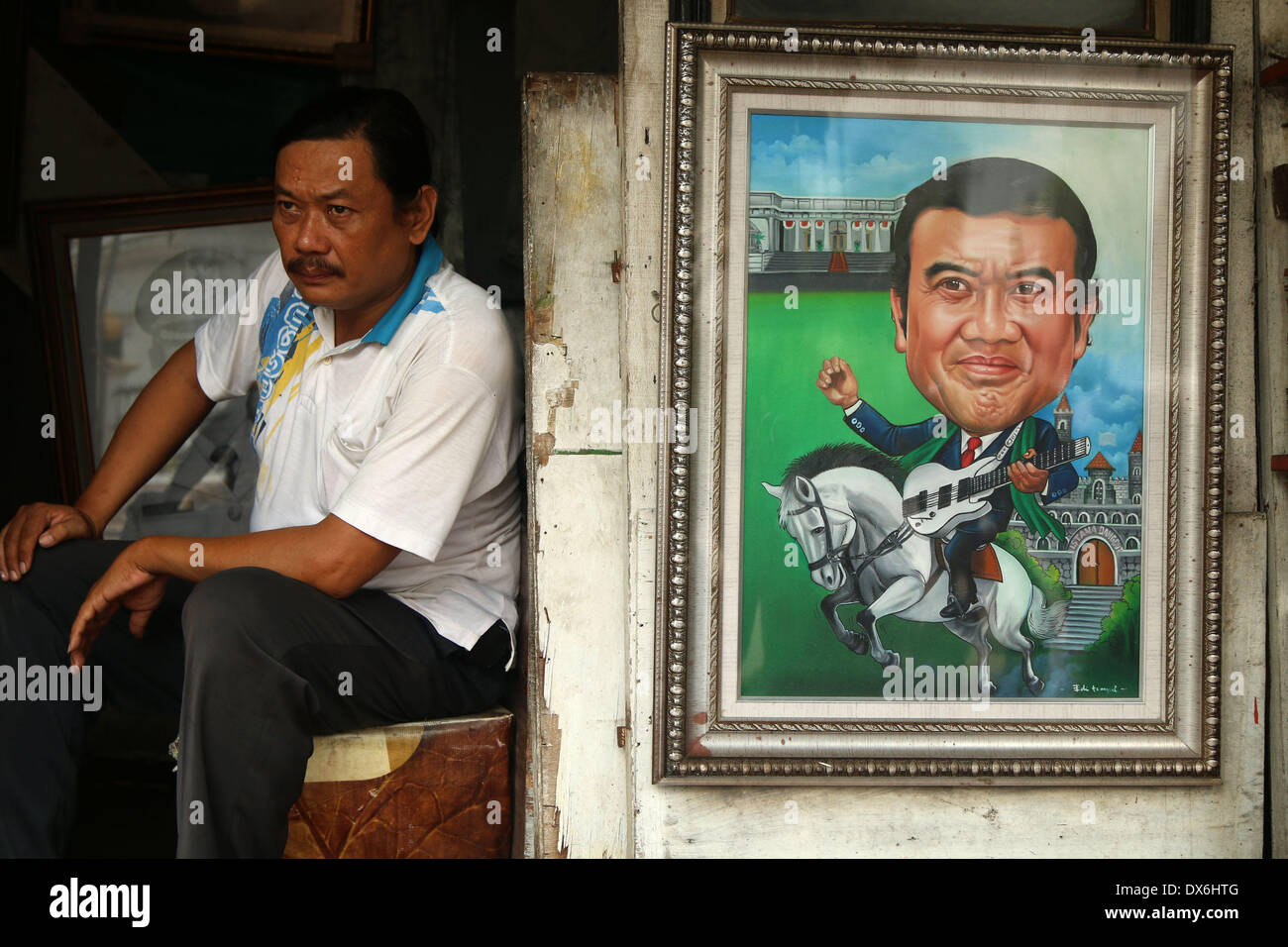 Jakarta, DKI Jakarta, Indonesia. 19th Mar, 2014. An artist painter sits near display of a painting of Dangdut Musician, Rhoma Irama who is running for president for the National Awakening Party (PKB) at Street Painting Shop Vendor in Jakarta. March 19, 2014. Indonesia the world's biggest Muslim-majority nation with 250 million people, will hold legislative polls in April and elect a new president in July, with some 180 million voters eligible to take part. Credit:  Jeff Aries/ZUMAPRESS.com/Alamy Live News Stock Photo