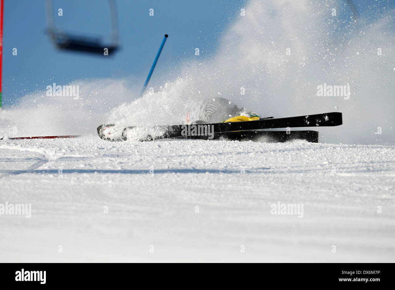 A snow skier falling out of control while racing on the slalom course ...