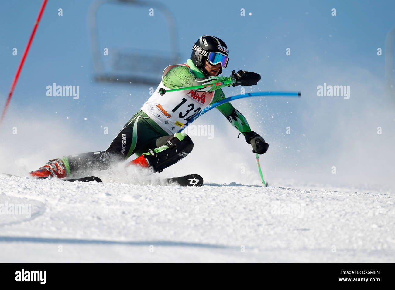 An alpine skier at a gate while racing on the slalom course Stock Photo