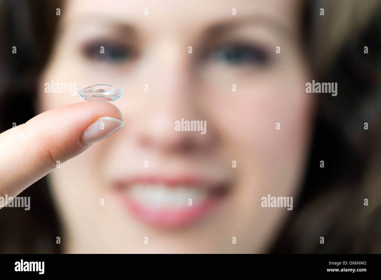 Closeup of a face of a woman with a contact lense on her finger Stock Photo