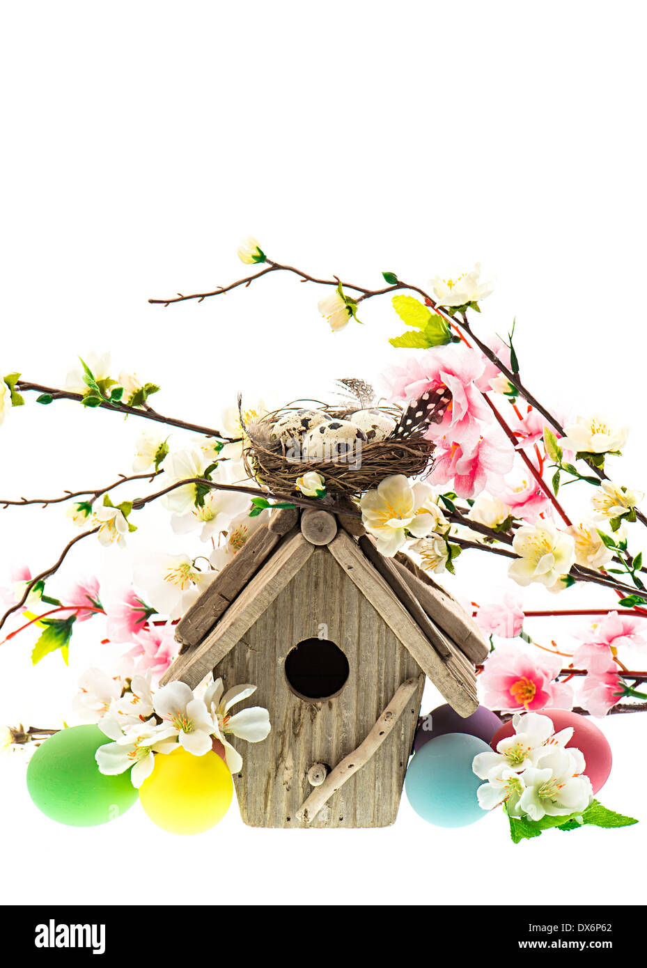 colorful easter decoration with birdhouse and eggs. spring apple and cherry blossoming Stock Photo