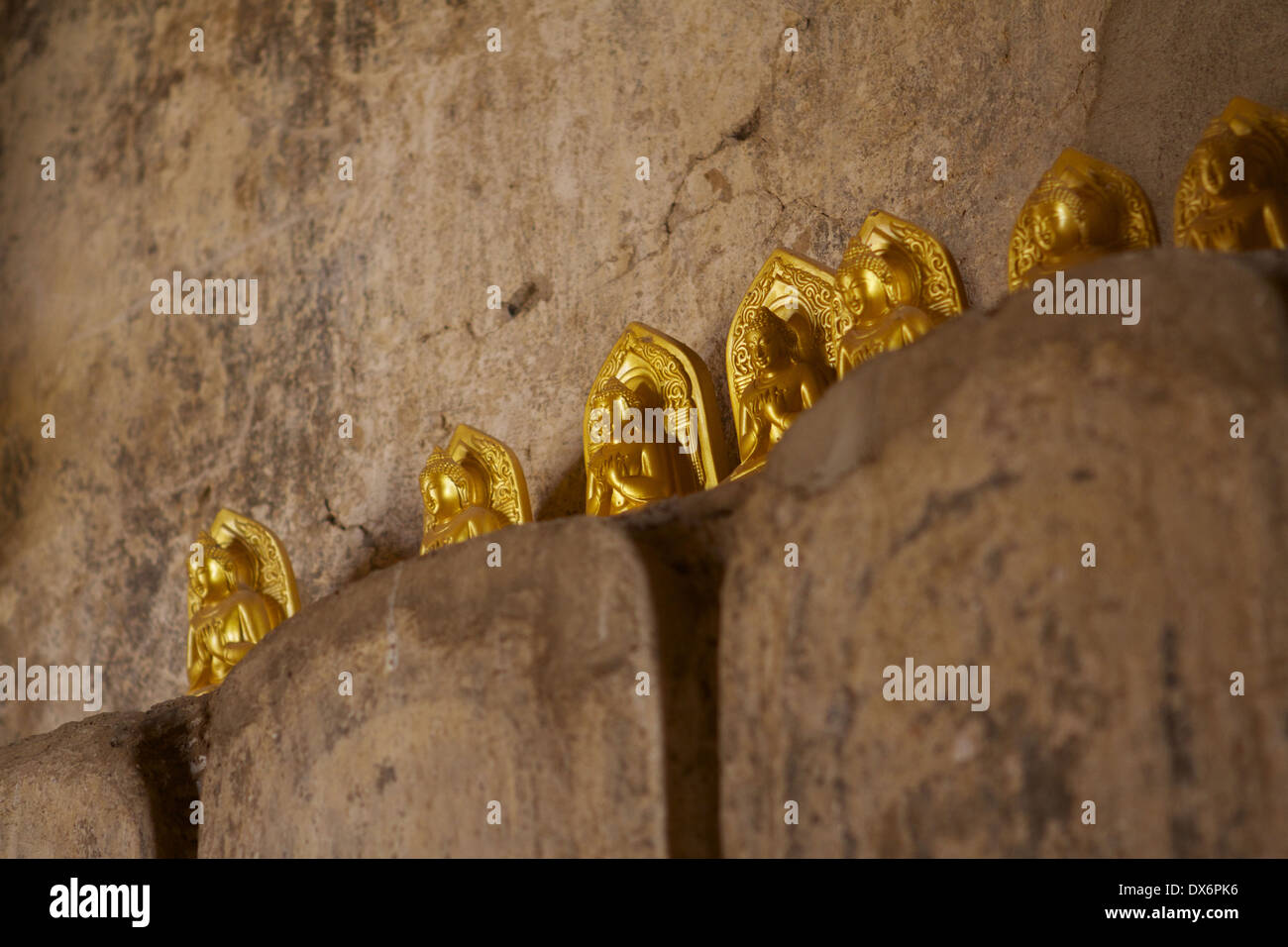 Miniature gold coloured Buddhas left as offerings to Buddha at Shwegugyi Temple meaning 'the Golden Cave' (a.k.a. Nandaw Oo Stock Photo