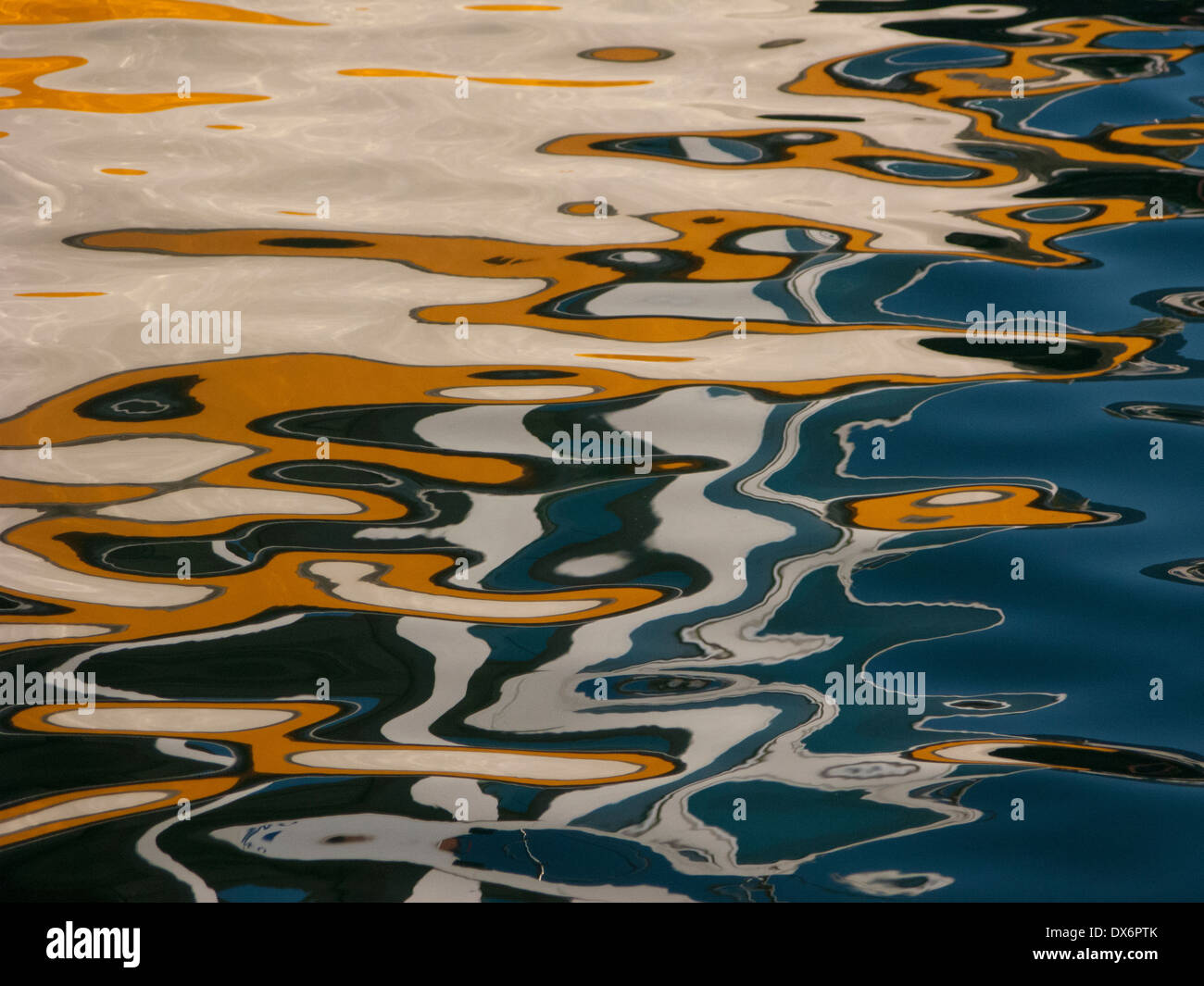 Abstract reflections of painted traditional boats on calm water, Chania harbor, Crete, Greece Stock Photo