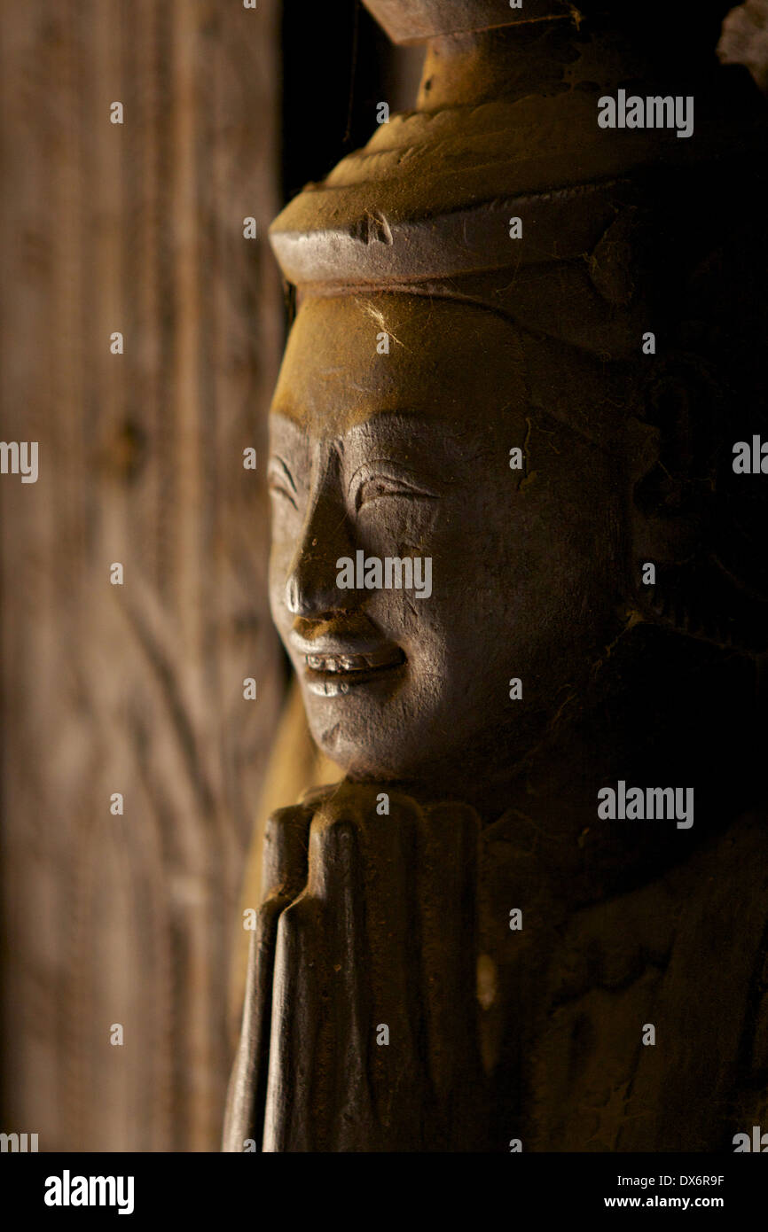 A cobweb covered carved wooden figure on panels and doors within the Shwe In Bin Kyaung monastery, a teak monastery in Mandalay Stock Photo