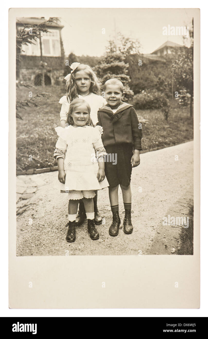 BERLIN, GERMANY - CIRCA 1916: group of children wearing vintage clothing with a old house on background, circa 1916 in Berlin Stock Photo