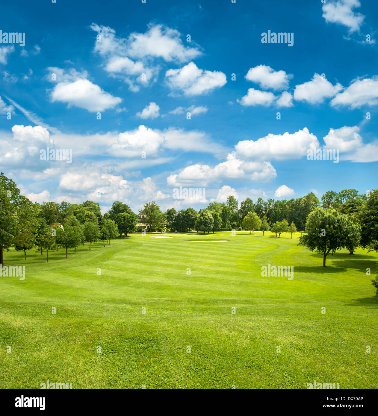 green golf field and blue cloudy sky. european landscape Stock Photo