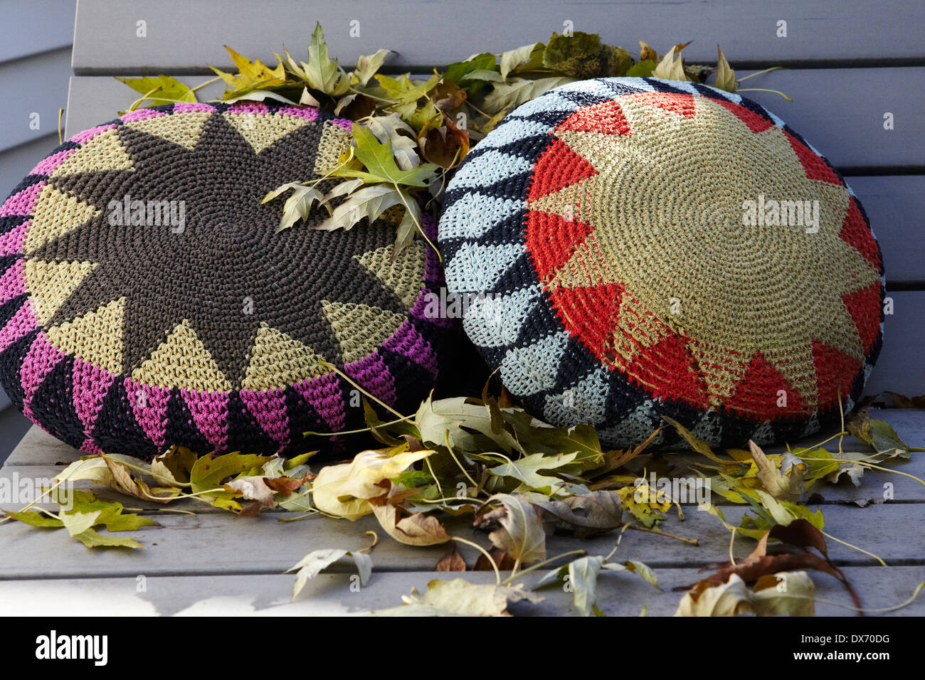 Crochet pillows on bench with autumn leaves Stock Photo Alamy