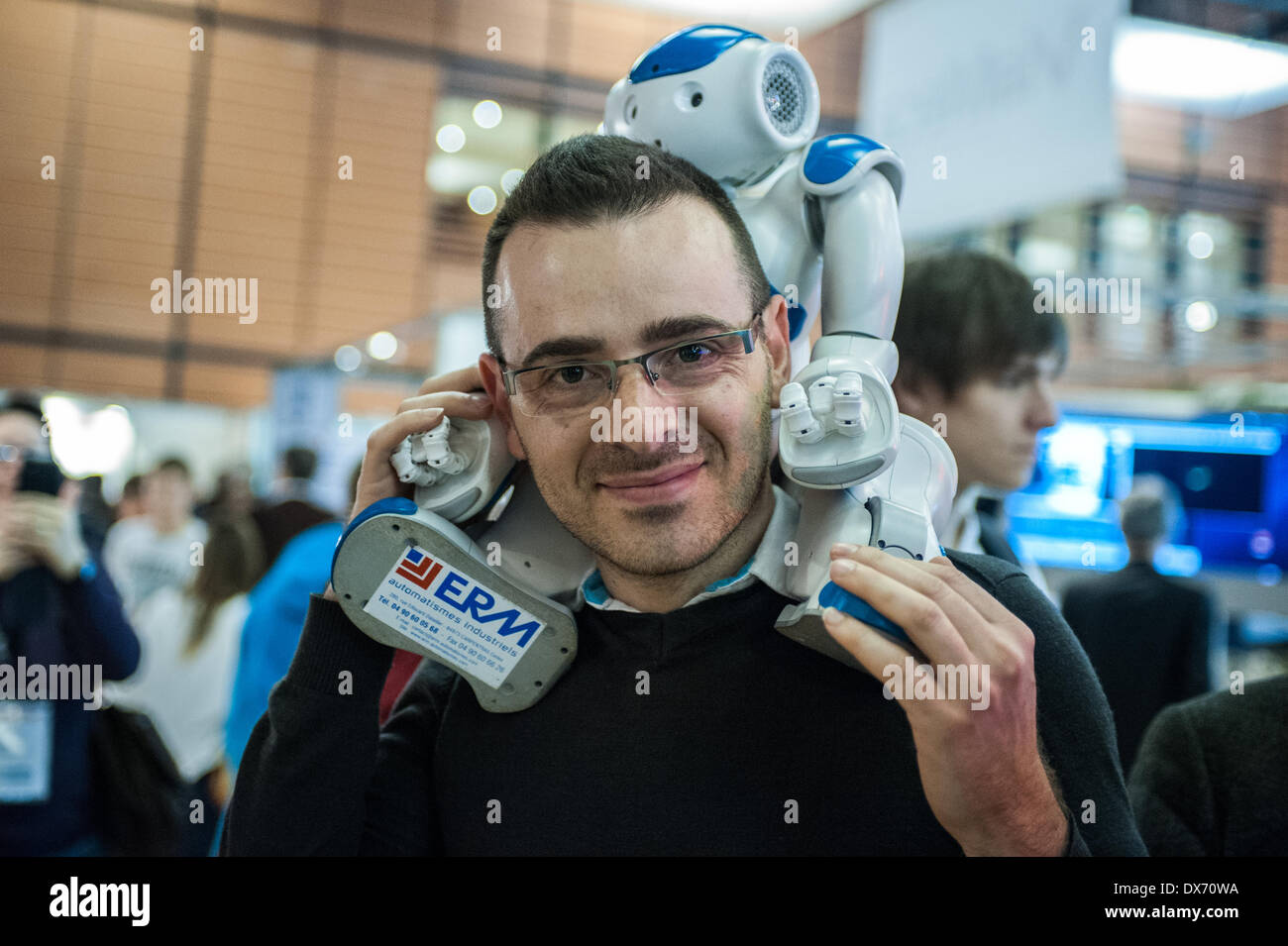 Lyon, France - 19 March 2014: a man brings NAO Robot by Aldebaran on his shoulders at Innorobo 2014, the biggest fair in Europe for robotics. Credit:  Piero Cruciatti/Alamy Live News Stock Photo