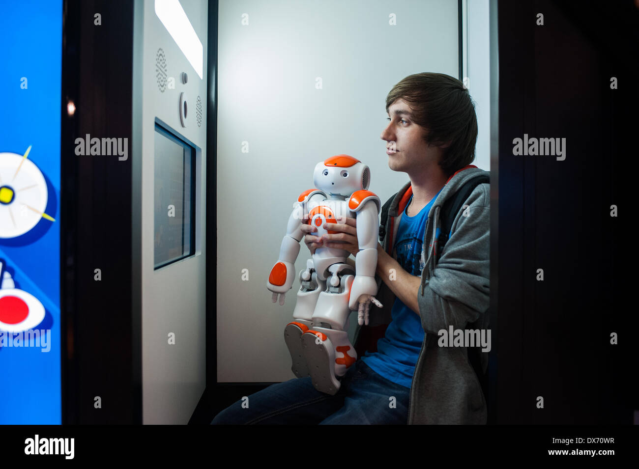 Lyon, France - 19 March 2014: a young man poses for a picture with robot NAO by Aldebaran at Innorobo 2014, the 4th international trade show on service robotics. Credit:  Piero Cruciatti/Alamy Live News Stock Photo