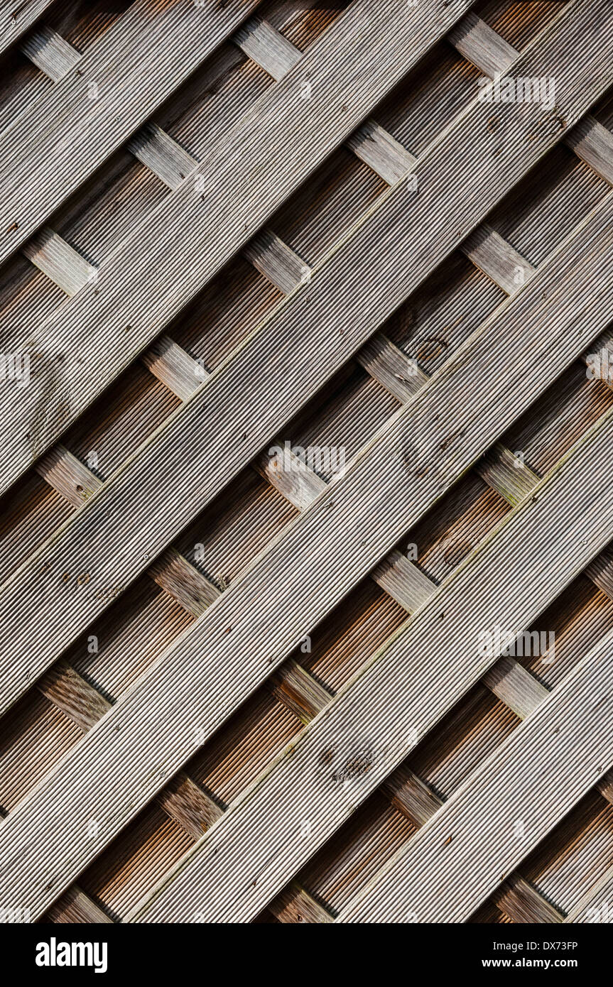 Wooden fence paneling, diagonal shapes, landscape side-lit. Stock Photo