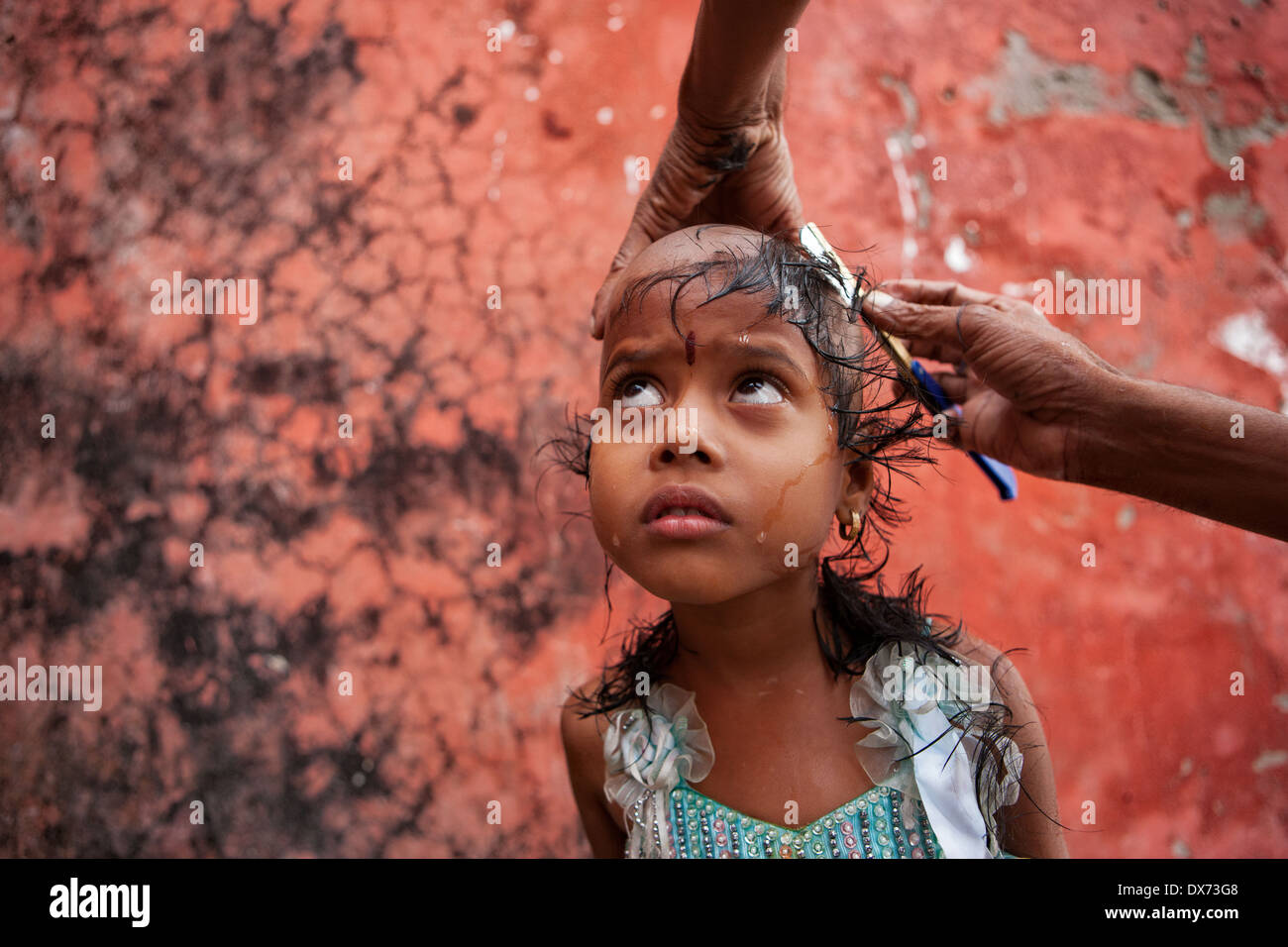 Varanasi - Daughter of a dead father shaving her head after the funeral. Stock Photo