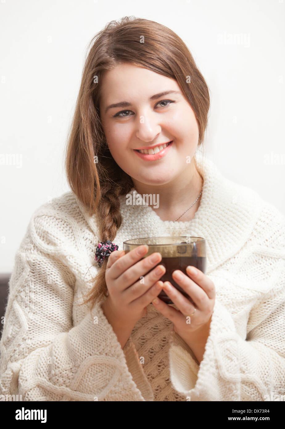 Portrait of smiling woman sitting on sofa and holding tea cup Stock ...