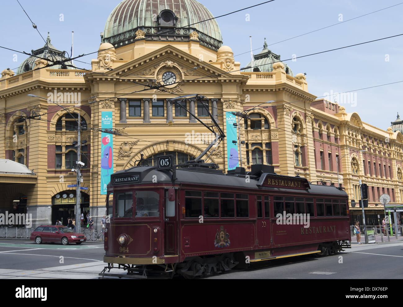 A heritage tram now used as a restaurant car on Flinders Street passing Flinders Street station