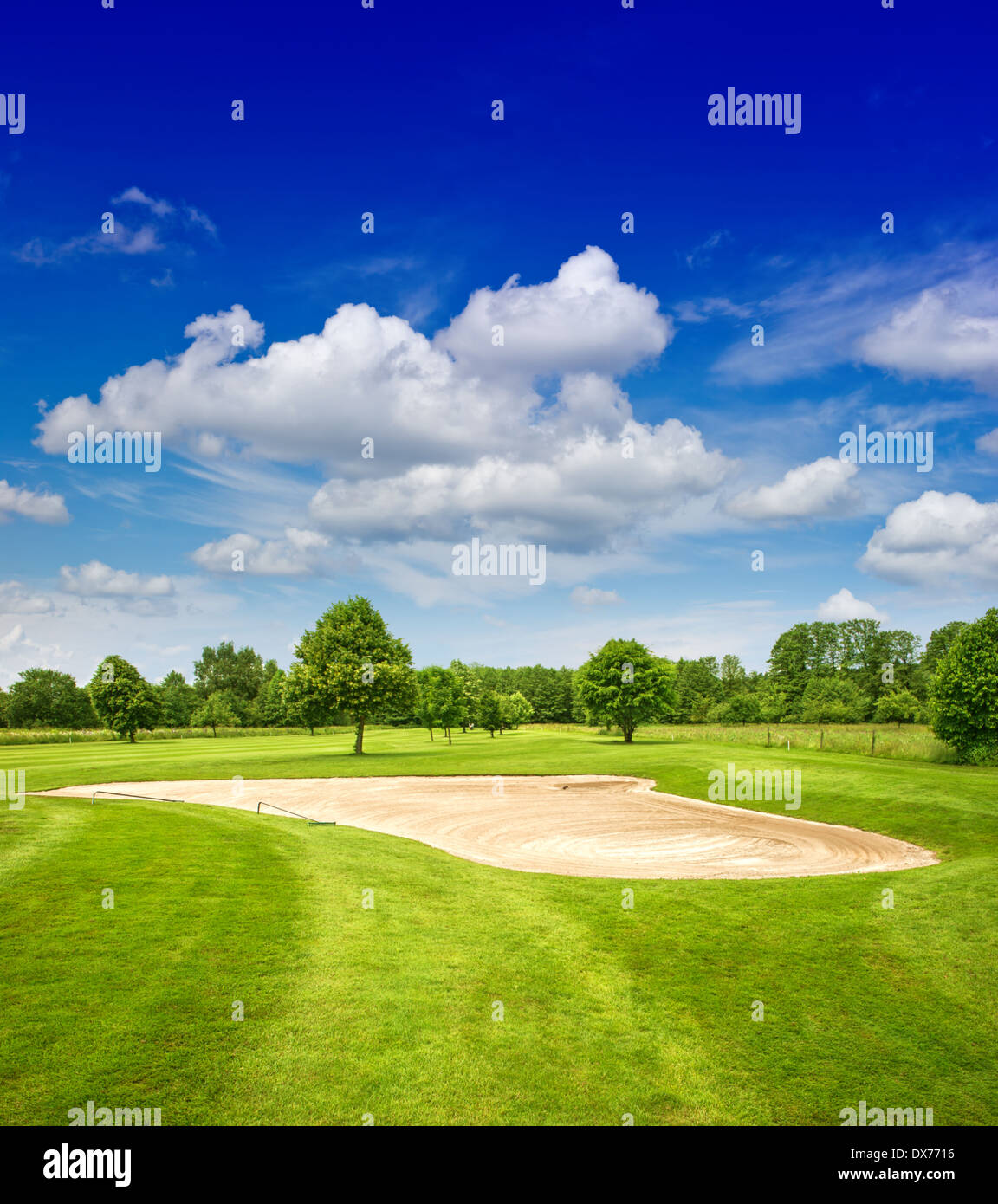 green golf course and dramatic blue sky. european field landscape Stock Photo