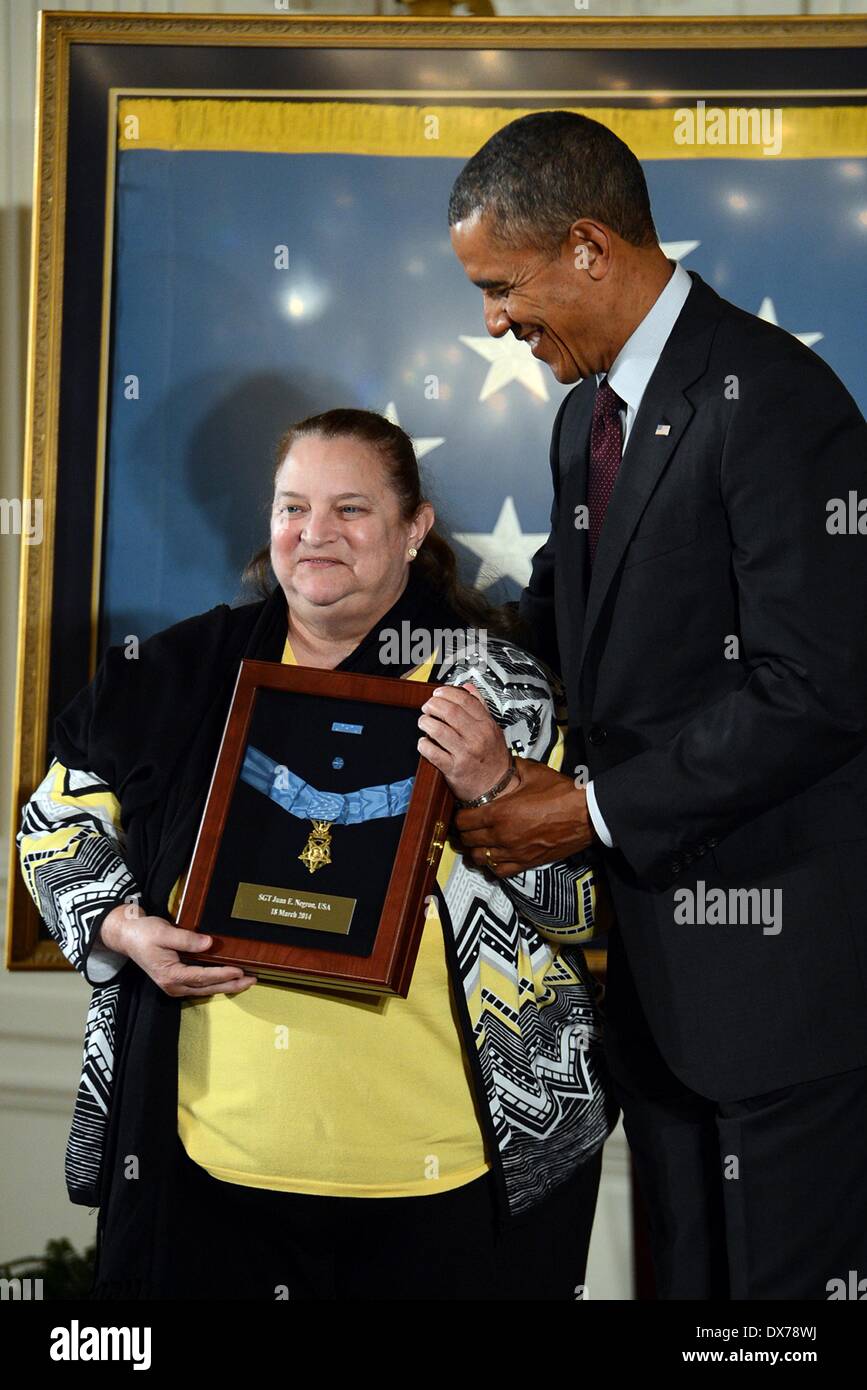 US President Barack Obama presents the Medal of Honor to Iris Negron on behalf of her late father Sgt. Juan E. Negron, one of 24 Army veterans to receive the award as part of the Valor 24 ceremony held at the White House March 18, 2014 in Washington D.C. Sgt. Juan E. Negron distinguished himself by acts of gallantry and intrepidity above and beyond the call of duty in Kalma-Eri, Korea on April 28, 1951. Stock Photo