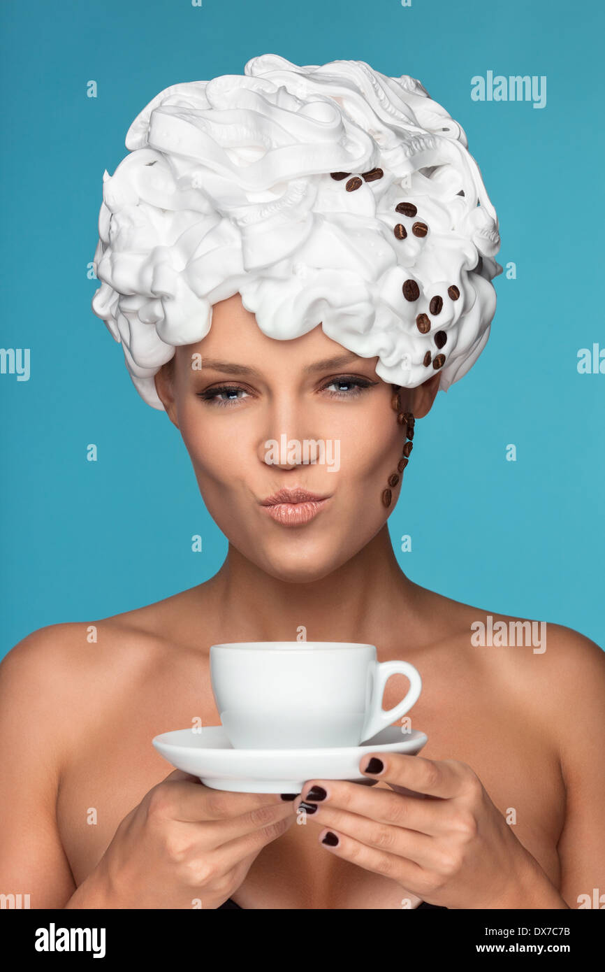 A young lady in a whipped cream on her head with a coffee cup Stock