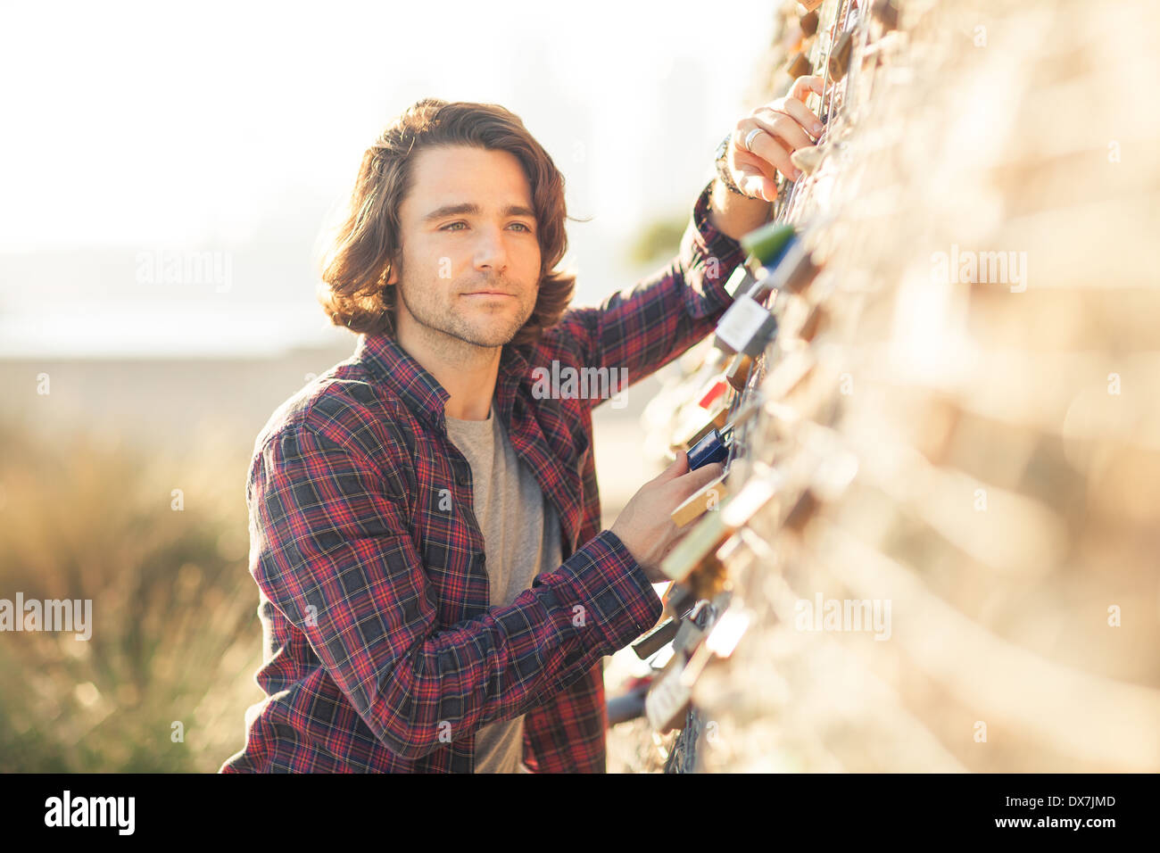 A young man looking thoughtful and serious in an outdoors setting Stock Photo