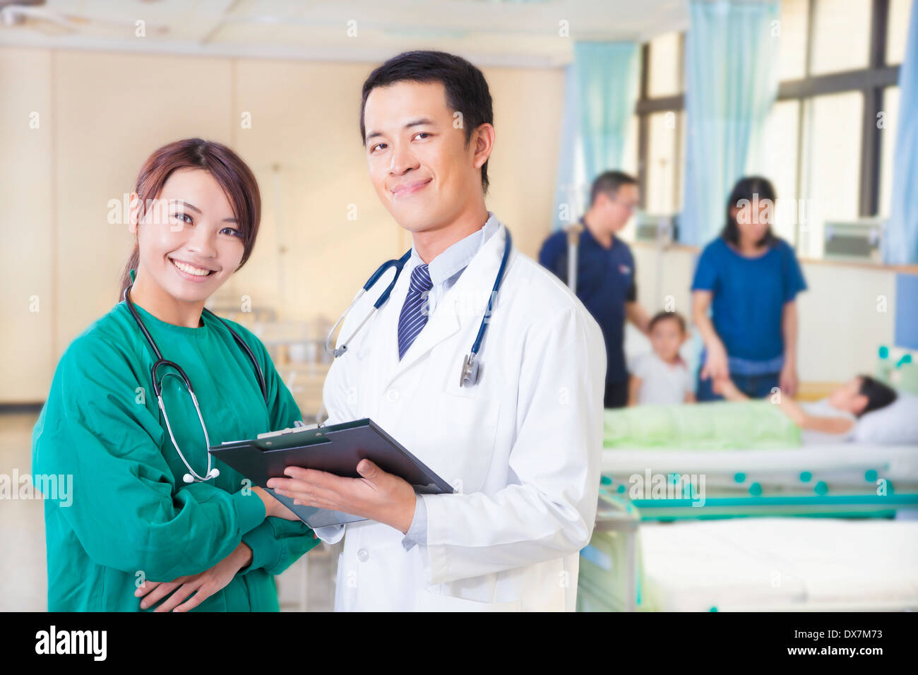 smiling doctor and assistant with patient in hospital Stock Photo