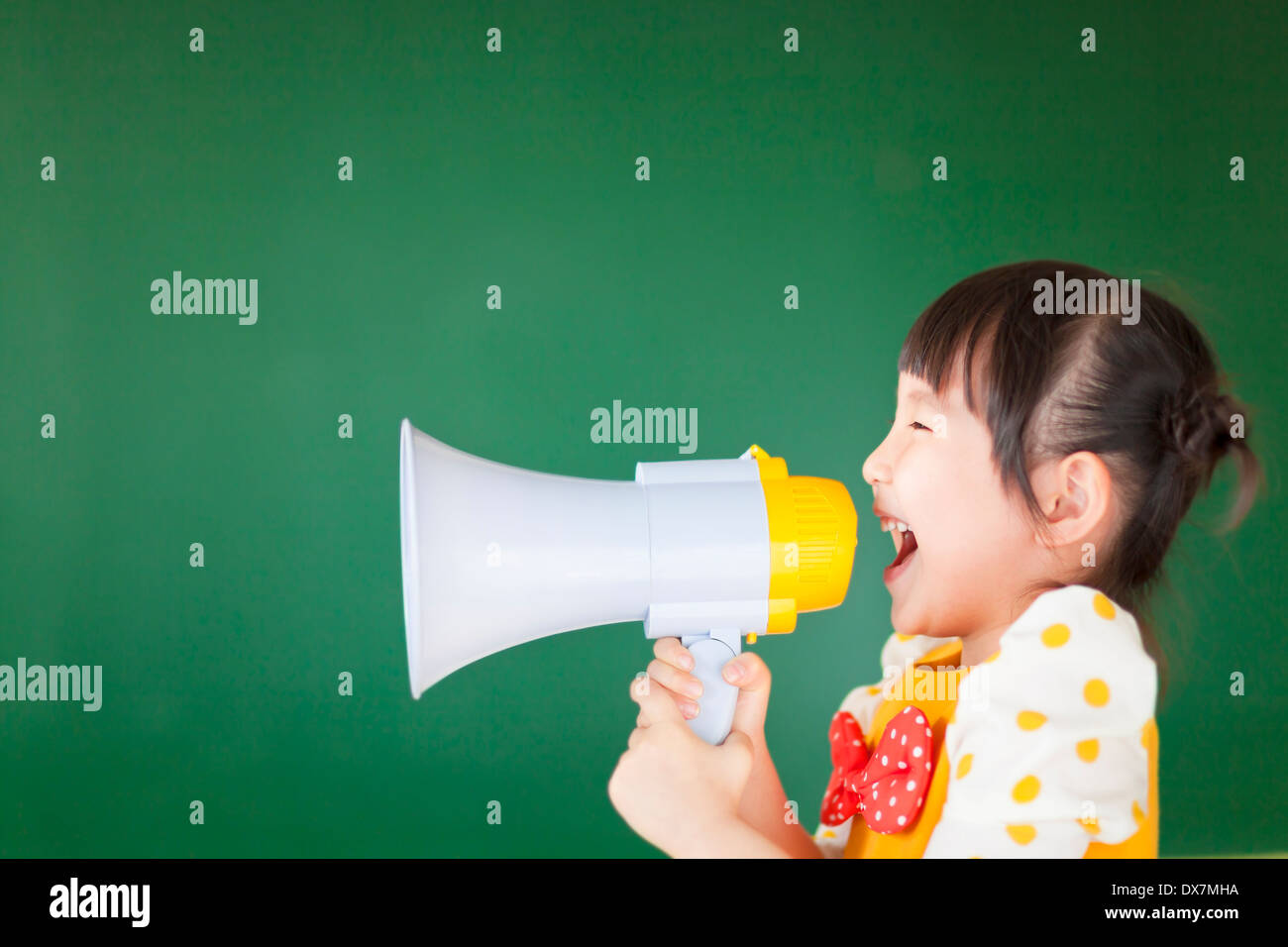 happy kid shouts something into the megaphone with board Stock Photo