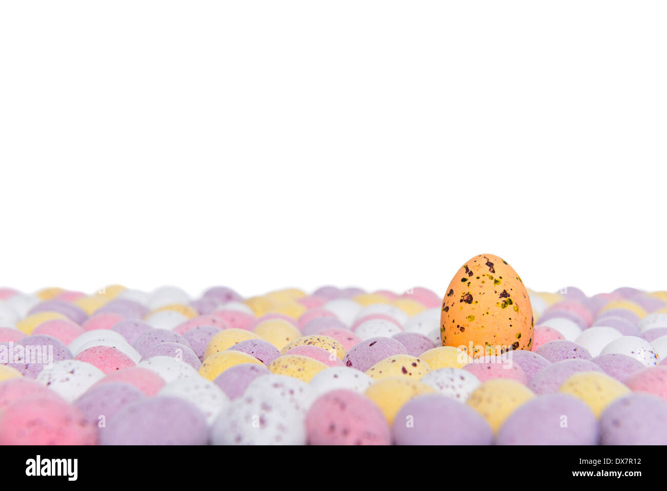 Candy covered chocolate easter eggs with one rising above the others, space above for your own message. Stock Photo